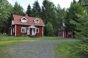 une maison rouge au milieu d'une cour dans l'établissement Torp ved Mårbacka (Helt hus til leie) Östra Ämtervik/ Sunne, à Östra Ämtervik