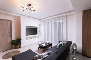 a living room with a couch and a tv at Athena Home South Crete in Kapparianá