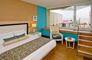 ein Hotelzimmer mit einem Bett und einem Balkon in der Unterkunft Herods Dead Sea – A Premium Collection by Fattal Hotels in Ein Bokek