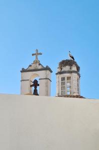 a cross on top of a wall next to a church at The Singular - Downtown Studio in Faro