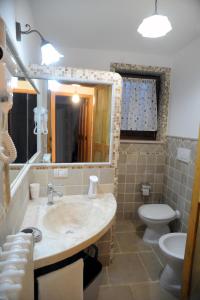 uma casa de banho com um lavatório, um WC e um espelho. em Casa Vacanze - Al Ma Chlo' em Fasano