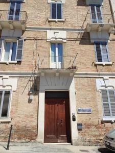 a brick building with a wooden door and a balcony at B&B Domvs tva in Chieti