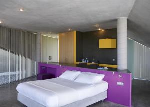 a bedroom with a large bed with a purple headboard at Leivatho Hotel in Svoronata