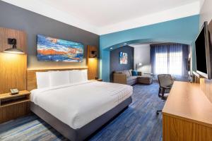 a hotel room with a bed and a television at La Quinta by Wyndham St. George in St. George