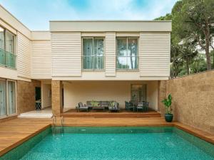 a house with a swimming pool in front of a house at Rixos Premium Belek - The Land of Legends Access in Belek