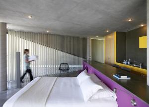 a man walking through a bedroom with a large bed at Leivatho Hotel in Svoronata
