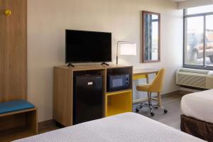 a hotel room with a bed and a television and a desk at Days Inn by Wyndham Winchester in Winchester