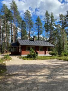 a small red house in the middle of a forest at Lomanaamanka Villa Kanerva in Syöte