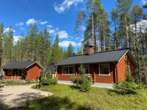 eine Hütte im Wald mit schwarzem Dach in der Unterkunft Lomanaamanka Villa Kanerva in Syöte