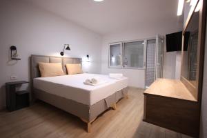 a bedroom with a large bed and a flat screen tv at Enjoy Apartments Prilep in Prilep