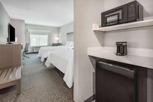 a hotel room with two beds and a microwave at La Quinta Inn & Suites by Wyndham Jackson-Cape Girardeau in Jackson