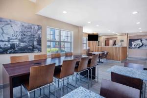una sala da pranzo con un grande tavolo e sedie di Super 8 by Wyndham Joliet a Joliet