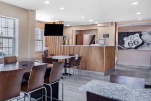 ein Restaurant mit Tischen und Stühlen und eine Küche in der Unterkunft Super 8 by Wyndham Joliet in Joliet