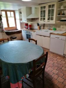 eine Küche mit einem Tisch mit einem grünen Polka-Punkt-Tisch in der Unterkunft Maison de 3 chambres avec jardin amenage et wifi a Taintrux in Taintrux