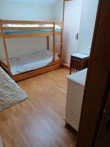 a room with two bunk beds and a wooden floor at Maison de 3 chambres avec jardin amenage et wifi a Taintrux in Taintrux