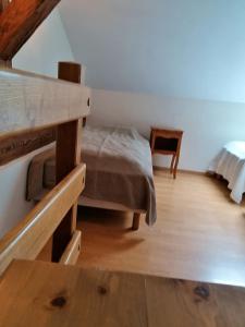 Schlafzimmer mit einem Bett und Holzboden in der Unterkunft Maison de 3 chambres avec jardin amenage et wifi a Taintrux in Taintrux