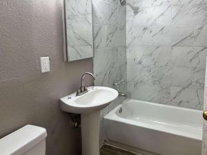a bathroom with a sink and a tub and a toilet at Motel 6 Las Vegas NV Downtown Fremont St in Las Vegas
