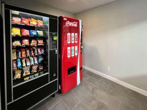 a cocacola soda machine next to a refrigerator at Motel 6 Las Vegas NV Downtown Fremont St in Las Vegas