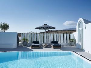 a swimming pool with two chairs and an umbrella at Relaxing and Ambient Santorini Villa 2 Bedrooms Cave Stone Villa Private Pool and Lovely Views Exo Gialos in Karterados