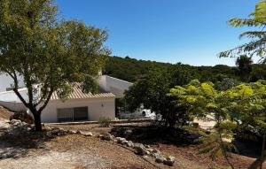 una casa bianca con degli alberi di fronte di Casa do Poço a Burgau