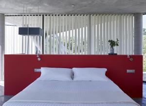 a bed in a room with a red head board at Leivatho Hotel in Svoronata