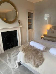 a room with a bed with a mirror and a fireplace at Luxury Georgian Apartment - 5 Minute Walk to Spa in Bath