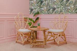 Chaipat Hotel في كون كاين: طاولة و كرسيين وطاولة مع نبات