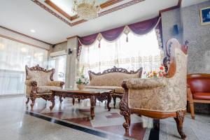 uma sala de estar com duas cadeiras e uma mesa em Chaipat Hotel em Khon Kaen