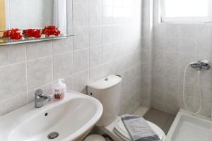 Łazienka z białą toaletą i umywalką w obiekcie Kalami Rooms w mieście Falasarna