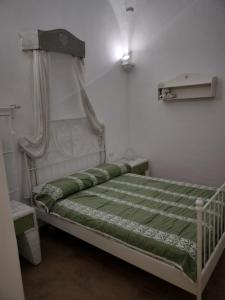 een kleine slaapkamer met een hemelbed bij Country house GALLINARO in Castellana Grotte