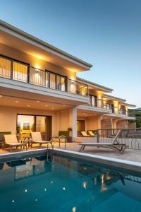 a house with a swimming pool in front of a house at PARGA 4 SEASONS VILLAS in Parga