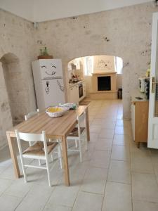 een keuken en eetkamer met een houten tafel en stoelen bij Country house GALLINARO in Castellana Grotte