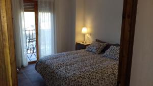 1 dormitorio con 1 cama con lámpara y balcón en Casa del Arrabal, en Montefrío