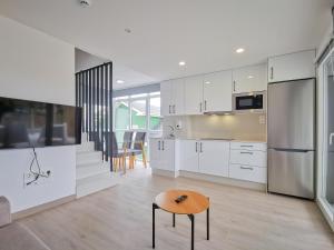 a kitchen with white cabinets and a wooden table at Duerming Playa de Foz VUT in Foz