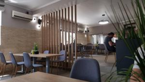 a man standing in a restaurant with tables and chairs at Pensiunea Verde in Cluj-Napoca