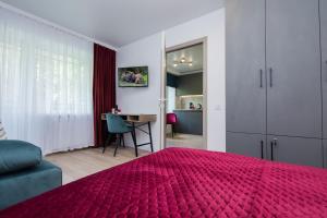 1 Schlafzimmer mit einem roten Bett und einem Esszimmer in der Unterkunft MYFREEDOM Апартаменти Залізничний Вокзал in Kiew