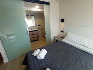 a bedroom with a bed with two towels on it at Bahia Rooms Cantabria 3000 in Santander