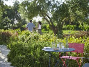 a table and chairs in a garden with people walking in the background at Leivatho Hotel in Svoronata