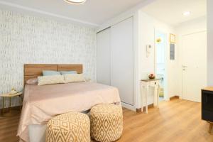 ein Schlafzimmer mit einem Bett und zwei Ottomanen in der Unterkunft Designer Studio Apartment 100m from the Beach in Las Palmas de Gran Canaria