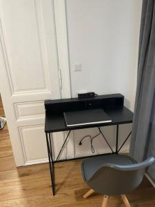 a black desk with a chair and a laptop at StayQuality Apartments Vienna #1 in Vienna