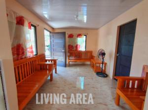 a living area with wooden benches and windows at Patar White Beach Bolinao- Lilybeth's Transient House in Bolinao