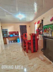 a kitchen with a dining area with a table and a refrigerator at Patar White Beach Bolinao- Lilybeth's Transient House in Bolinao