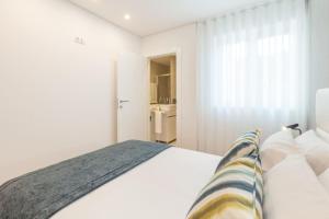 a white bedroom with a bed and a bathroom at Art's Braga Apartment - Minho's Guest in Braga