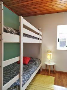 a bunk bed room with two bunk beds and a table at Casa d´Amado in Sanxenxo