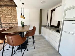 cocina con mesa y sillas en una habitación en Apartamentos Puerta Elvira Suites 3000 en Granada