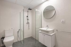 格拉纳达Apartamentos Puerta Elvira Suites 3000的带水槽和淋浴的白色浴室