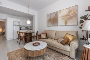 格拉纳达Apartamentos Puerta Elvira Suites 3000的带沙发和桌子的客厅