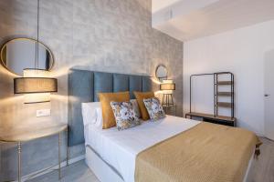 格拉纳达Apartamentos Puerta Elvira Suites 3000的卧室里有一张带蓝色床头板的床 更多37张照片