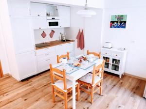 a kitchen with a table and chairs in a kitchen at Casina Alpina sugli impianti Passo S Pellegrino in Passo San Pellegrino