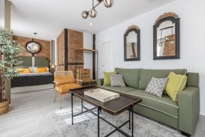 格拉纳达Apartamentos Puerta Elvira Suites 3000的客厅里有一张绿色的沙发和一张桌子